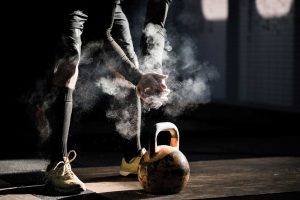 Man dusting hands over kettle bell