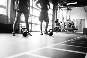 Two people working out near kettle bells