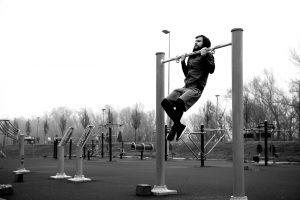 Man doing pull up in park